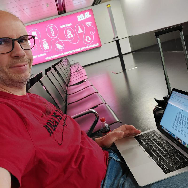 Odhaľte tajomstvá mojej produktivity! Maroš Sollár na letisku s notebookom na kolenách si robí selfie.